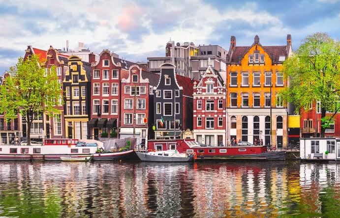 Colourful canal houses and boats in Amsterdam